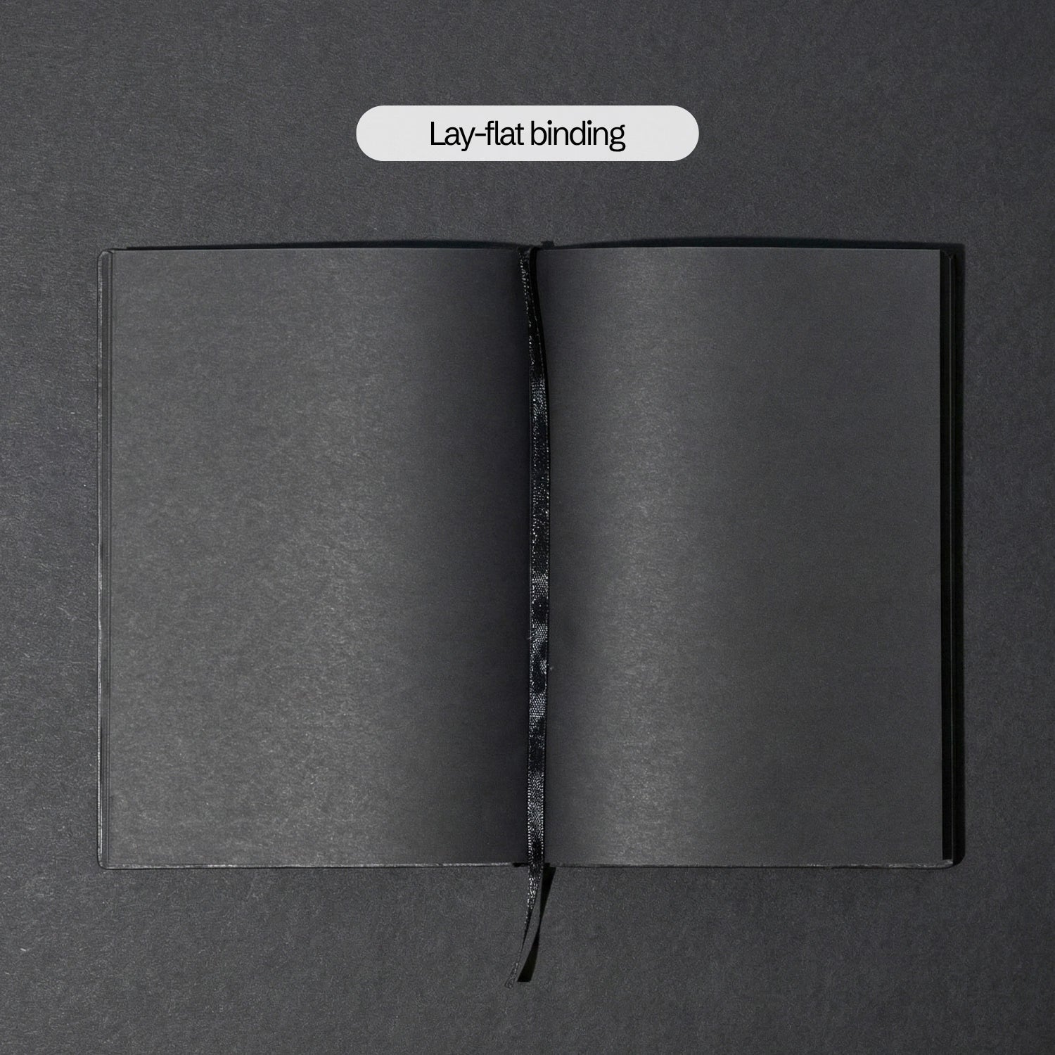 The Notebook open completely flat, ribbon bookmark down the centre